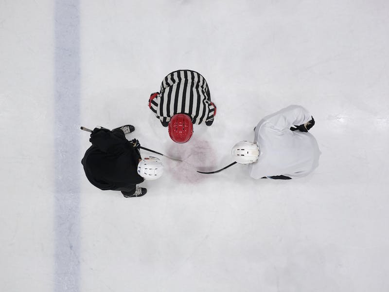 A Referee and Hockey Players on an Ice Rink